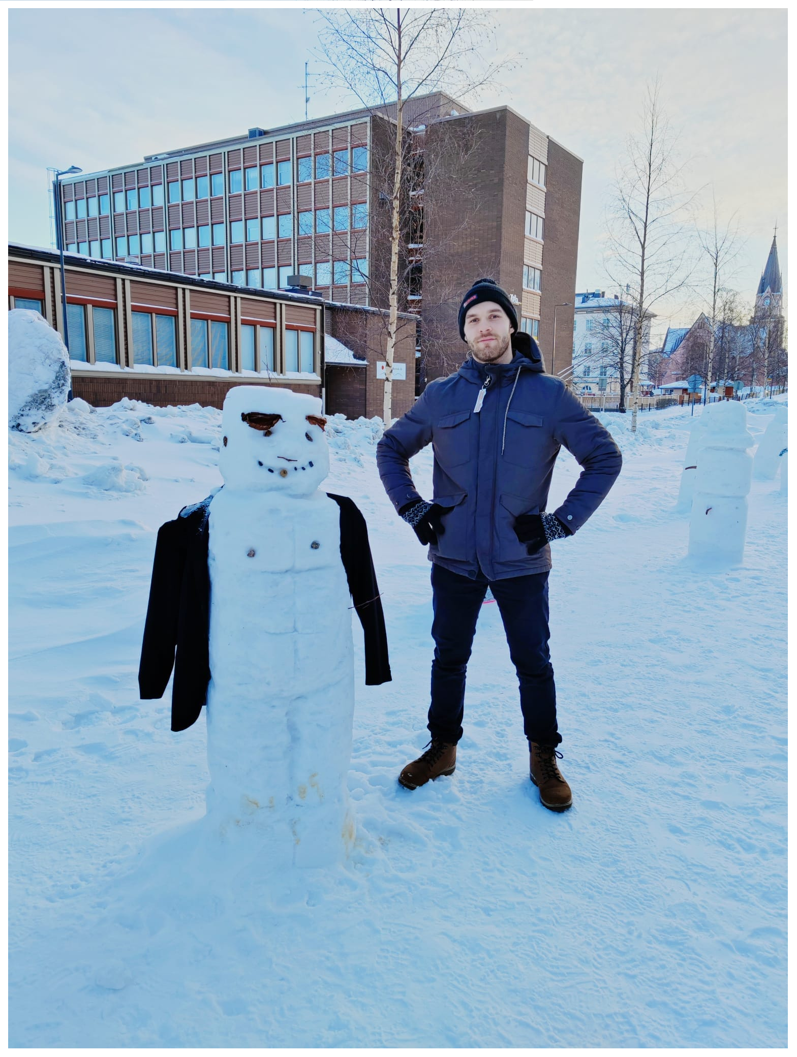 Kuvassa opiskeluhuollon psykologi Petteri Ruuhijärvi ulkona talvella, vieressään lumiukko.