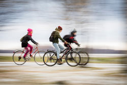 Kokokuvassa kolme nuorta pyöräilemässä.