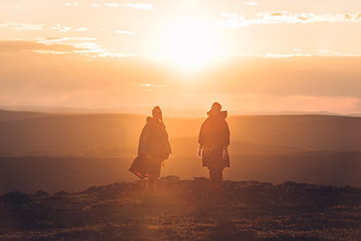 Kaksi naista auringon edessä tunturilla