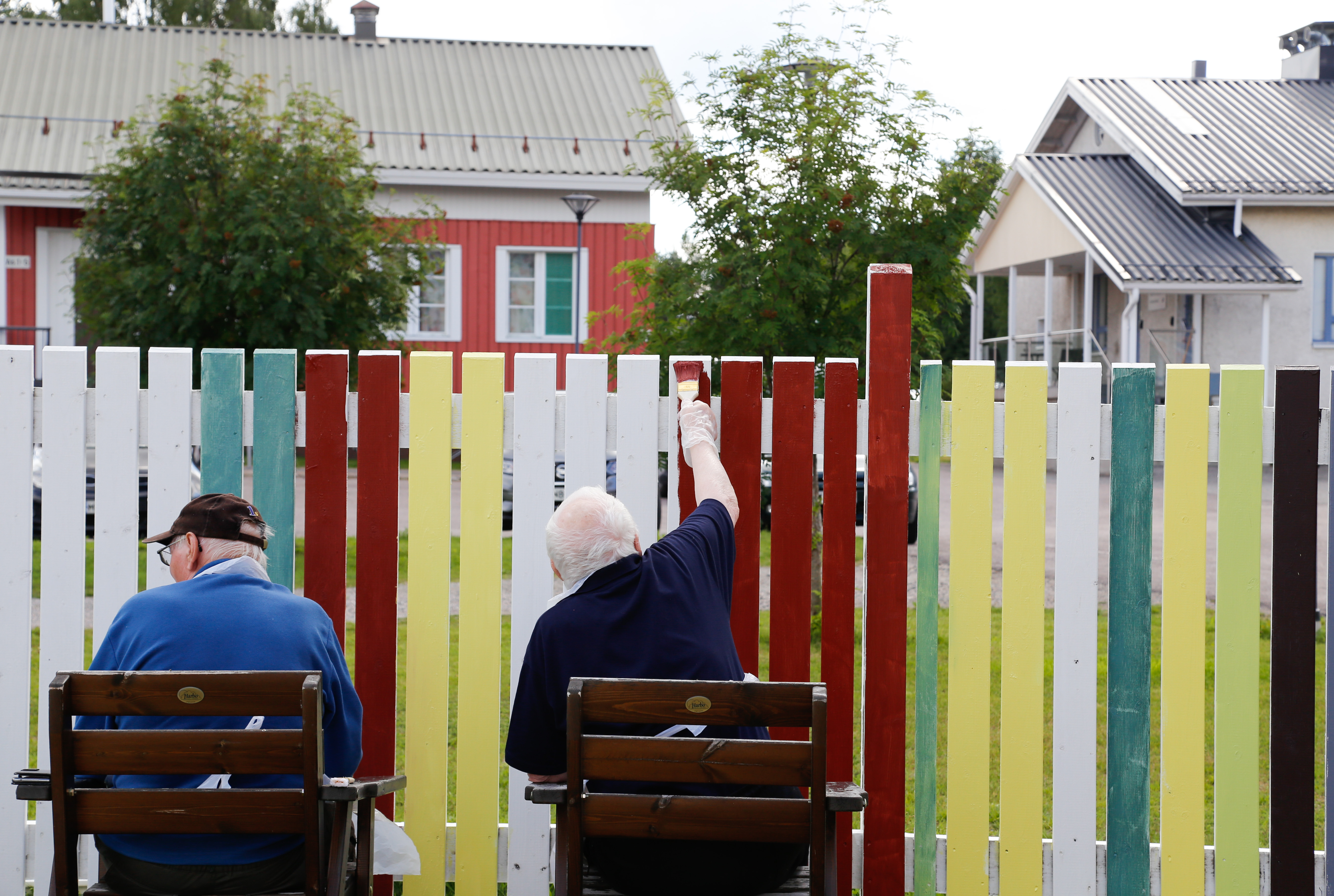 Vanhuksia istuu tuoleissa maalaamassa osallisuuden aitaa Kittilän Koivukodilla kesällä 2023.