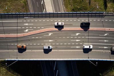 Kuvassa on monikaistainen silta ylhäältä kuvattuna. Siltaa ylittää viisi autoa.